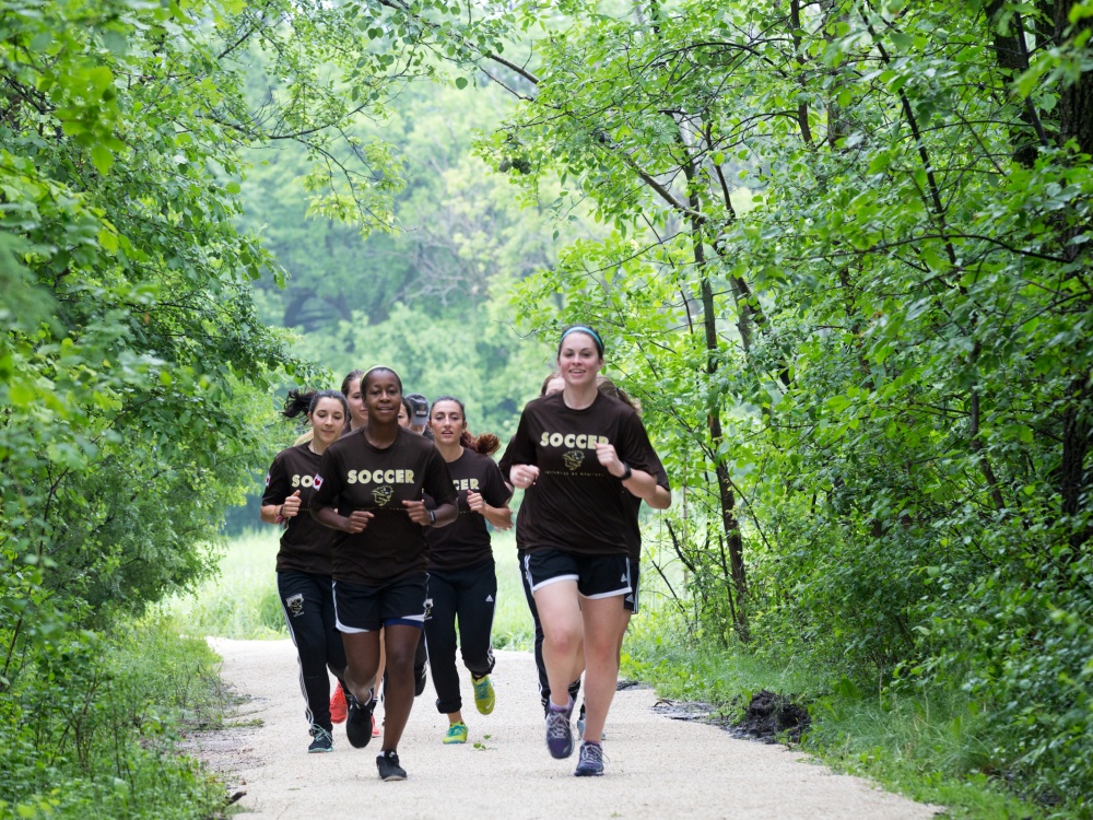 group of young women jogging along a path at Assiniboine Park